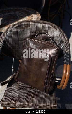 Brown leather backpack on the stylish chair Stock Photo