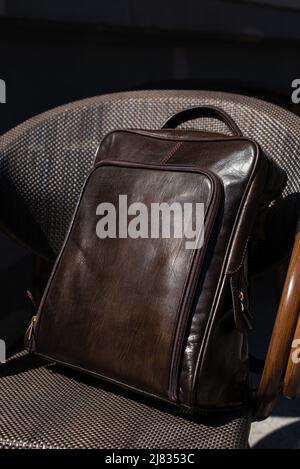 Brown leather backpack on the stylish chair Stock Photo