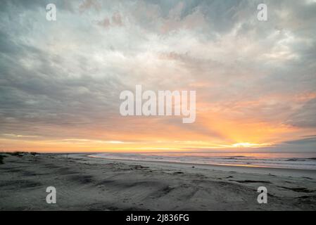 Dawn sky and sunrise over beach with clouds and Atlantic Ocean, Hunting Island, South Carolina Coast Stock Photo
