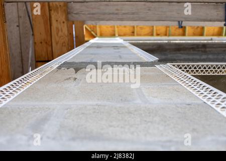 view upwards on a corner wall of a multiplex apartment building with corner beading applied to the sides for stucco application. Stock Photo