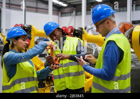 Group of engineers working on the functioning of machines Stock Photo