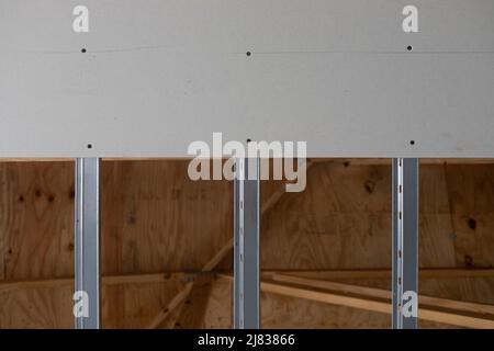 Overhead installed ceiling drywall or sheetrock showing galvanized steel rails for installation for the next sheet Stock Photo