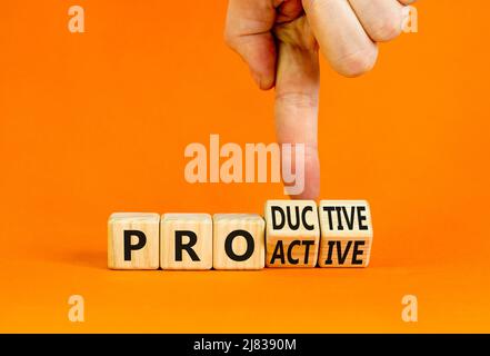 Proactive and productive symbol. Businessman turns cubes and changes the concept word Productive to Proactive. Beautiful orange background. Business, Stock Photo