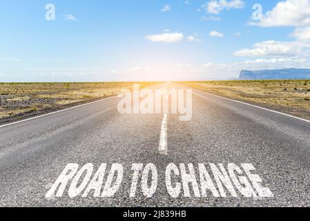 Road to change. Conceptual image of a deserted straight road through a desert landscape with the text 'road to change' written on asphalt Stock Photo