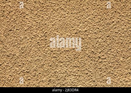 Beige wall texture, background. Decor of yellowish textured coating. Structural plaster, rough, uneven surface in beige color. Modern exterior Stock Photo