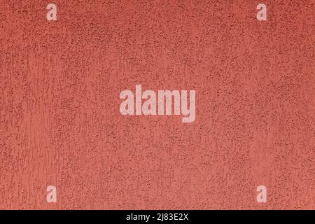 Red wall, texture, background. Plastered building wall. Rough,  textured and decorated surface with vertical embossed pattern. Chaotic, abstract color Stock Photo