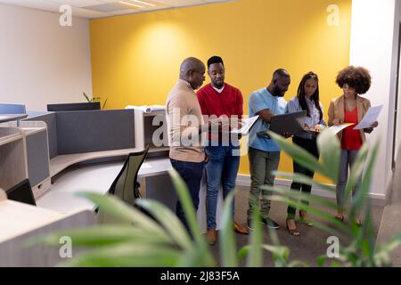 Multiracial business colleagues discussing strategy in modern workplace Stock Photo