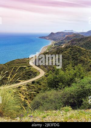 View from above of winding coastal road in hilly landscape. Cabo de Gata Nijar nature Park, Carboneras, Almeria Province, Andalusia, Spain Stock Photo