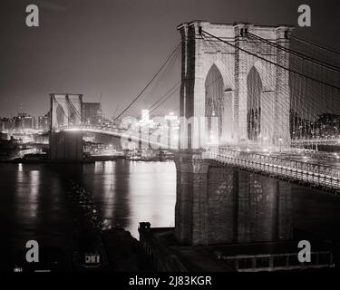 1960s NIGHT SCENE OF BROOKLYN BRIDGE VIEW ACROSS THE EAST RIVER TOWARD BROOKLYN FROM MANHATTAN NEW YORK CITY USA - b23122 HAR001 HARS HYBRID CONNECTION CONCEPTUAL NEW YORK ACROSS CITIES NEW YORK CITY CHARACTERISTIC OR CREATIVITY MAY 24 NEO-GOTHIC NIGHTTIME SPAN 1883 BLACK AND WHITE BRIDGES HAR001 JOIN OLD FASHIONED SUSPENSION TOWERS