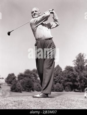 1940s 1950s MIDDLE-AGED MAN COMPLETING HIS SWING AS HE HAS JUST TEED OFF NOW LOOKING DOWN FAIRWAY - g77 HAR001 HARS SATISFACTION ELDER HEALTHINESS TEE COPY SPACE FULL-LENGTH PERSONS MALES JUST GOLFING RETIREMENT MIDDLE-AGED B&W MIDDLE-AGED MAN RETIREE ACTIVITY HAPPINESS PHYSICAL OLD AGE WELLNESS OLDSTERS OLDSTER GOLFERS HIS LEISURE STRENGTH LOW ANGLE RECREATION FAIRWAY PRIDE NOW ELDERS FLEXIBILITY LINKS MUSCLES COMPLETING HE TEED BLACK AND WHITE CAUCASIAN ETHNICITY HAR001 OLD FASHIONED Stock Photo