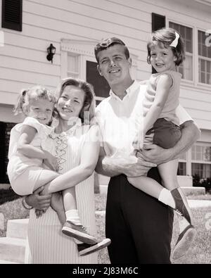 1960s SMILING PORTRAIT FAMILY OF FOUR MOTHER FATHER TWO KIDS DAUGHTERS IN FRONT OF SUBURBAN HOUSE  - j12203 HAR001 HARS 4 COMMUNITY SUBURBAN MOTHERS OLD TIME NOSTALGIA OLD FASHION SISTER 1 JUVENILE STYLE WELCOME YOUNG ADULT FAMILIES JOY LIFESTYLE SATISFACTION FEMALES HOUSES MARRIED SPOUSE HUSBANDS HOME LIFE COPY SPACE FRIENDSHIP HALF-LENGTH LADIES DAUGHTERS PERSONS INSPIRATION RESIDENTIAL MALES BUILDINGS SIBLINGS CONFIDENCE SISTERS FATHERS B&W PARTNER SUMMERTIME EYE CONTACT GOALS SUCCESS DREAMS HAPPINESS BRIGHT DADS PRIDE HOMES SIBLING RESIDENCE IN FRONT OF COOPERATION GROWTH JUVENILES Stock Photo