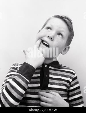 1960s BOY IN STRIPED T-SHIRT POINTING TO A TOOTH IN THE BACK OF HIS MOUTH THAT I CAUSING A TOOTH ACHE LOOKING UP - j11760 HAR001 HARS B&W DENTAL HUMOROUS HIS LOW ANGLE COMICAL UP GESTURES COMEDY GROWING UP T-SHIRT CAUSING GROWTH JUVENILES LOOKING UP ACHE BLACK AND WHITE CAUCASIAN ETHNICITY HAR001 OLD FASHIONED Stock Photo