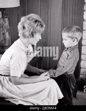 1960s MOTHER SON HOLDING HANDS TALKING SERIOUSLY ABOUT BEHAVIOR BOY WITH CONTRITE FACIAL EXPRESSION SORRY  - j12297 HAR001 HARS YOUNG ADULT INFORMATION SONS FAMILIES LIFESTYLE PARENTING HOME LIFE COPY SPACE HALF-LENGTH THOUGHTFUL DISCIPLINE INSPIRATION CARING MALES B&W PROTECTION SORRY MOTHER AND SON AUTHORITY CONNECTION MOTHERS AND SONS CONCEPTUAL SUPPORT SINCERE SERIOUSLY SOLEMN BEHAVIOR FOCUSED GROWTH INTENSE JUVENILES MOMS TOGETHERNESS YOUNG ADULT WOMAN BLACK AND WHITE CAREFUL CAUCASIAN ETHNICITY CONTRITE EARNEST HAR001 INTENT MANNERS OLD FASHIONED Stock Photo