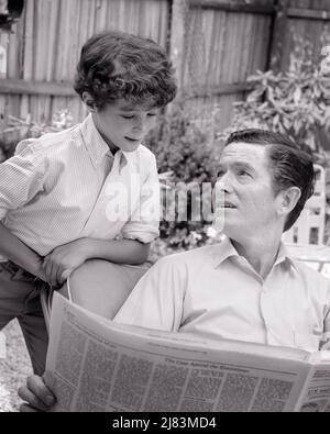 1960s SON READING OVER HIS FATHER’S SHOULDER DAD SITTING OUTSIDE ON PATIO READING NEWSPAPER BOY AS KING DAD ABOUT PAPER - j13203 HAR001 HARS COMMUNICATION INFORMATION SONS FAMILIES LIFESTYLE PATIO KING HOME LIFE COPY SPACE FRIENDSHIP HALF-LENGTH ASKING PERSONS INSPIRATION MALES CONFIDENCE FATHERS B&W HIS QUESTIONS BONDING DADS KNOWLEDGE LOW ANGLE QUESTION FATHER AND SON FATHER'S CONNECTION FATHERS AND SONS GROWTH JUVENILES MID-ADULT MID-ADULT MAN PRE-TEEN PRE-TEEN BOY TOGETHERNESS BLACK AND WHITE CASUAL CAUCASIAN ETHNICITY HAR001 OLD FASHIONED Stock Photo