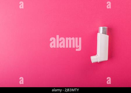 Directly above shot of white asthma inhaler isolated against pink background, copy space Stock Photo