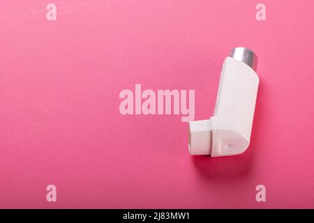 High angle view of white asthma inhaler isolated against pink background, copy space Stock Photo