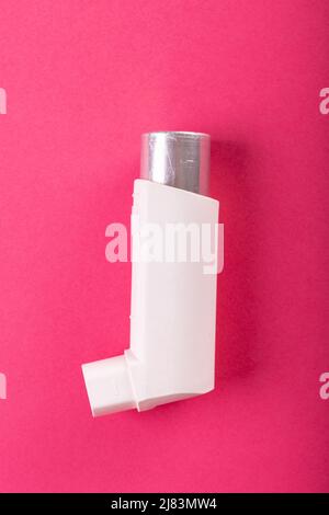 Close-up of white asthma inhaler isolated against pink background, copy space Stock Photo