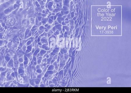 Clear water surface texture with splashes bubbles. Color of the year 2022 Very Peri. Pantone color 2022. Stock Photo