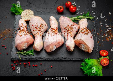 Raw chicken drumsticks with spices and vegetables. Top view. Healthy food concept. Stock Photo