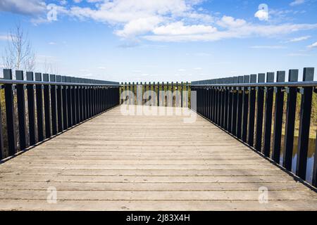 Wooden platform with steel handrails and love padlocks hanging on it Stock Photo
