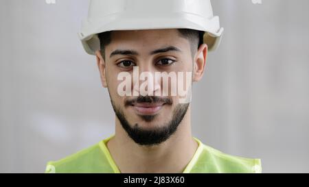 Front view male professional inspector arab man builder mechanic engineer worker wear special uniform hard hat smiling hispanic foreman posing for Stock Photo