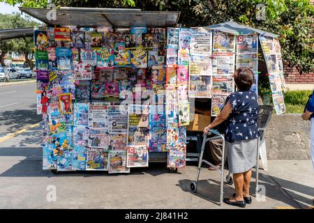 A Local Woman Looking At The Newspaper Headlines At A Newspaper/Magasine Kiosk, Trujillo, La Libertad Province, Peru. Stock Photo