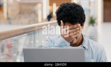 African american guy sad frustrated upset disappointed business man losing online bets getting rejected from bank email problems loser male laptop Stock Photo