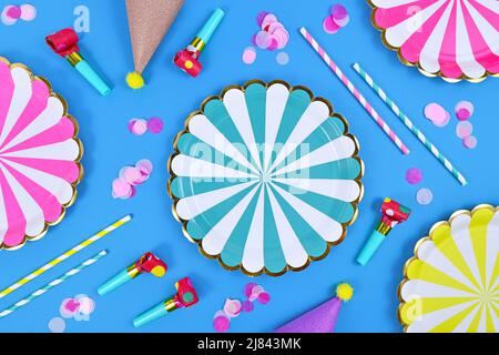 Party flat lay with paper plates, drinking straws and confetti on blue background Stock Photo
