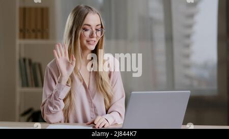 Caucasian female online teacher internet coach psychologist mentor specialist e-consultant business woman with papers at table speaks in laptop webcam Stock Photo