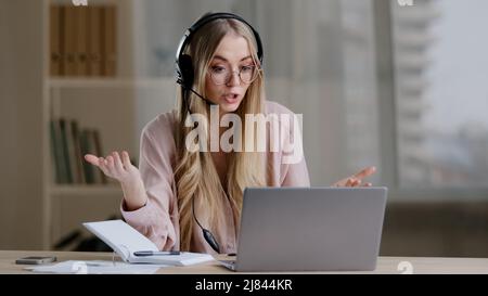 Millennial business woman online distant mentor in headset talking looking to camera showing explaining female professor teacher coach advisor Stock Photo
