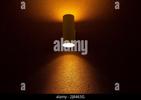 Goiânia, Goias, Brazil – May 11, 2022: A spotlight illuminating a yellow textured concrete wall. Stock Photo