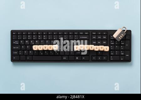 Conceptual image of online crime  - computer keyboard with wooden dice spelling cyber threats. Stock Photo
