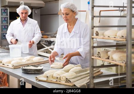 Female baker shaping dough Stock Photo