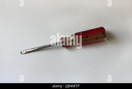 An Old Red and Yellow Flathead Screwdriver on a White Background Stock Photo