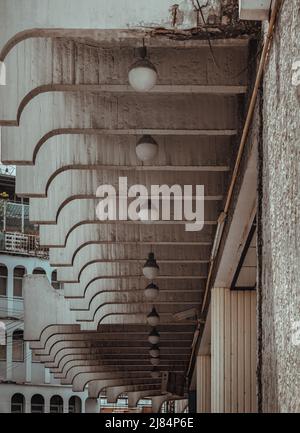 Many white vintage lamps that hangs under the ceiling of exterior building at Standalone old movie theater. Selective focus. Stock Photo