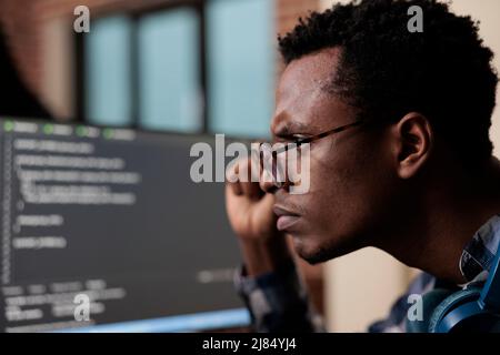 Computer programmer puzzled by nonfunctional security algorithm and company corrupted database. Confused tech engineer sitting doubtful at computer trying to solve network processing errors. Stock Photo