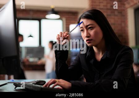 Thoughtful software developer thinking of ways to upgrade encryption program. Pensive network engineer reflecting at failed data processing operation and security system unknown breach. Stock Photo