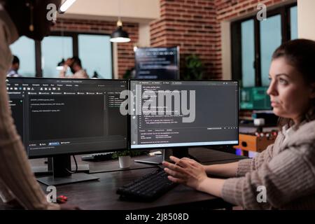 Programmers looking for source of cyber attacks and system security coverage. Software developer team members programming encryption applications to be used as security measure. Stock Photo
