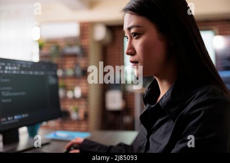 Tech engineer creating machine learning software to be used as an autonomous virtual entity. Confident asian network developer engineering application for company database. Stock Photo