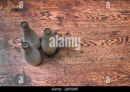Top view of empty glass wine bottles standing on wooden floor Stock Photo