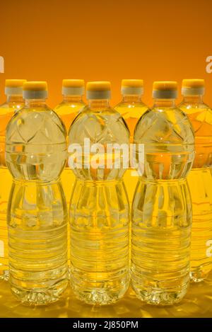 Plastic bottles with natural refined sunflower oil on orange color background Stock Photo
