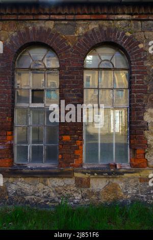 windows and red brick facade of old abandoned factory building in Germany Stock Photo