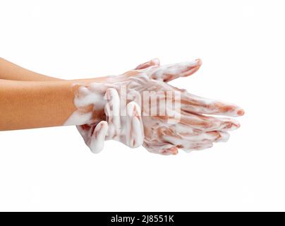 Female hand washing hands with soap lather on white background. Hands with white foam. Texture of white soap foam on female hand. Stock Photo