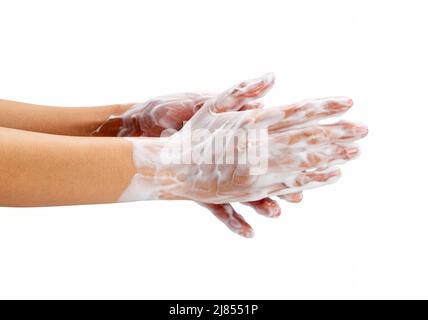 Female hand washing hands with soap lather on white background. Hands with white foam. Texture of white soap foam on female hand. Stock Photo