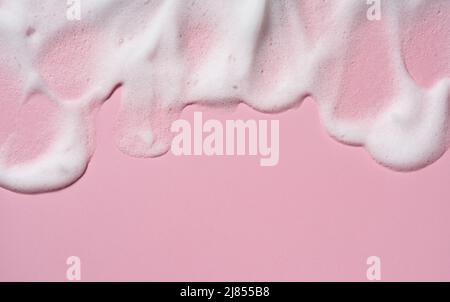 Texture of the foam of the skin care cleanser. Soap bubbles with copy space on pink background. Viewed from directly above. Stock Photo