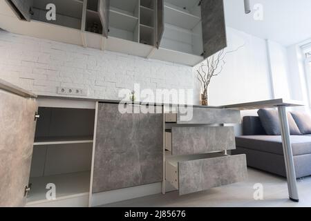Modern minimalistic dark gray loft style studio apartment interior design. kitchen, sitting area. Stock Photo