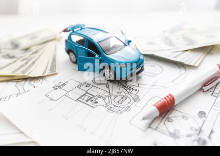 small car model and blueprint sheets. Stock Photo