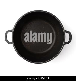 old empty round black cast-iron frying pan isolated on white background, kitchen utensil Stock Photo