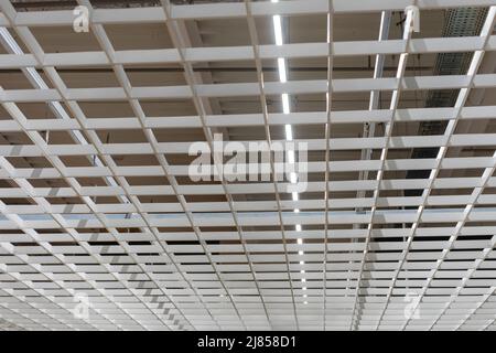 Suspended modern ceiling in the office. Loft style office ceiling design. Stock Photo