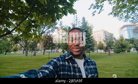 Web cam view happy cheerful african american man enthusiastic exited guy student teenager male holding camera selfie spinning rotating smiling Stock Photo